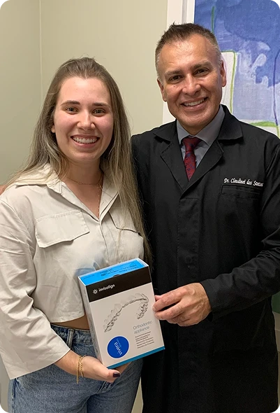 Dr. Claudinei dos Santos entregando o kit Invisalign a paciente na Clínica OdontoQuality.
