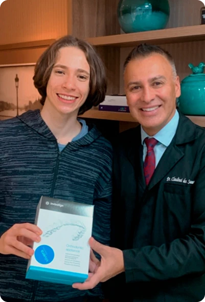 Dr. Claudinei dos Santos entregando o kit Invisalign a paciente na Clínica OdontoQuality.